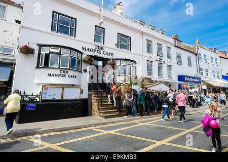 Whitbys Magpie Cafe, berühmt für die Qualität seiner Fish And Chips. Wie üblich, gibt es eine Warteschlange außerhalb. Stockfoto