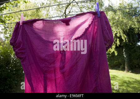 Bluse hängen zum Trocknen auf einer Wäscheleine in einem englischen Garten. Stockfoto