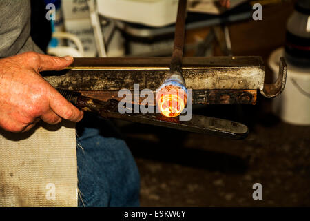 Eine hoch qualifizierte Handwerker, die Gestaltung der Glasschmelze zu einem Briefbeschwerer in Produktion. Stockfoto