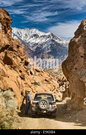Besucher und 4WD Fahrzeug auf der Straße im Red Rock Canyon, White Mountains in der Ferne, Mojave Desert bei Bishop, Kalifornien, USA Stockfoto