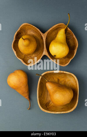 Reife Birnen in verschiedenen Schalen auf dunklem Hintergrund Stockfoto