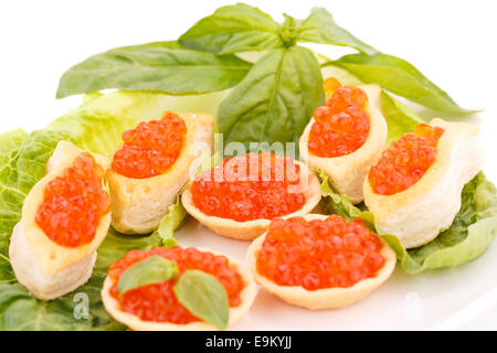 Roter Kaviar in Gebäck und Salat auf Teller. Stockfoto