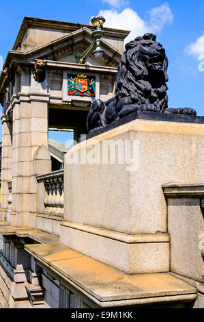 Eine prächtige Löwe aus Bronze, sitzt vor einem Säulen Portikus bewachen die Ansätze zur alten Brücke in Rochester Stockfoto