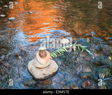 Felsen, die übereinander in Oak Creek bei Red Rock Crossing in Sedona, ausgewogen, mit goldenen Felsen im Wasser reflektiert Stockfoto