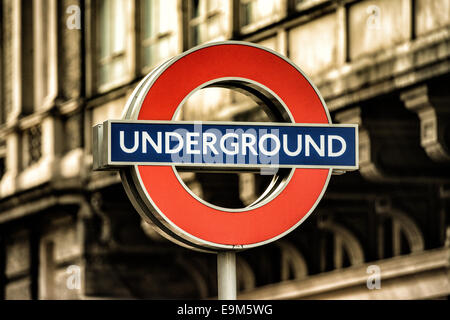 LONDON, Großbritannien – die berühmte U-Bahn-Station mit einem roten Kreis und einer blauen Bar markiert den Eingang zu einer U-Bahn-Station. Das Symbol ist seit 1908 ein Teil der visuellen Identität Londons und entwickelte sich von früheren Designs zu einem der weltweit bekanntesten Verkehrssymbole. Die Londoner U-Bahn, allgemein bekannt als die U-Bahn, eröffnete ihre erste Linie im Jahr 1863 und ist eines der ältesten und umfangreichsten U-Bahn-Netze der Welt. Transport for London unterhält dieses Netz, das täglich Millionen von Passagieren über mehr als 270 Bahnhöfe bedient. Stockfoto
