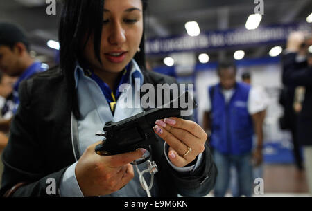 Bogota, Kolumbien. 29. Oktober 2014. Ein Besucher sieht eine Waffe an der 4. internationalen Messe der Verteidigung und Sicherheit "Expodefensa" in Bogota, der Hauptstadt Kolumbiens, 29. Oktober 2014. Der "Expodefensa" fair, spezialisiert auf die technologische Entwicklung und Innovation für Verteidigung und Sicherheit, am 29.-31. Okt. statt. © Jhon Paz/Xinhua/Alamy Live-Nachrichten Stockfoto