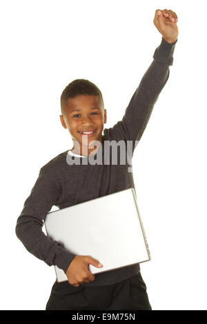 Hübscher elfjährige afroamerikanische Junge hält einen Laptop-Computer und lächelnd aufgeregt auf weißem Grund Stockfoto