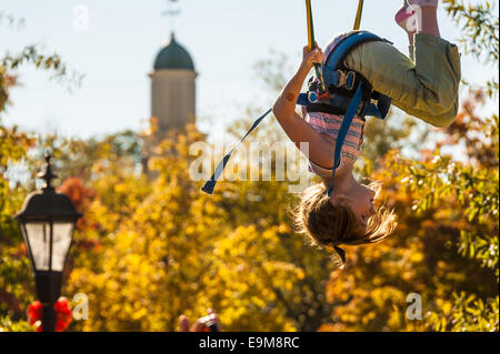 Mädchen machen Purzelbäume während Prellen auf einen Bungee-Sprung auf dem Snellville Herbstfestival in der Nähe von Atlanta, Georgia, USA. Stockfoto