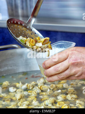 Touristischen erhält eine Portion gekochte Schnecken auf der Straße in Frankreich Stockfoto