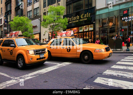 NEW YORK CITY, NEW YORK, USA - 19. Mai 2013: Taxis häuften sich im Verkehr auf der 5th Avenue, Manhattan vor dem Oxford-Cafe. Neu Stockfoto