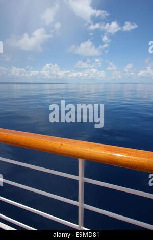 Blick auf ein ruhiges Meer noch an einem schönen sonnigen Tag mit Handlauf eines Kreuzfahrtschiffes im Vordergrund, indischen Ozean. Stockfoto