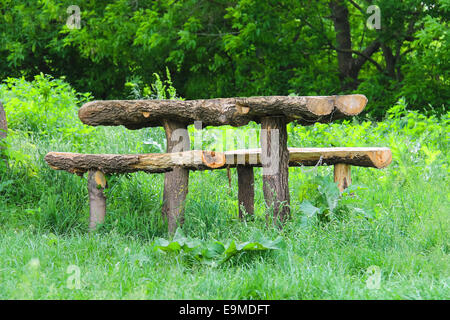 Tisch und Bänke aus Blockstamm sind im Wald Stockfoto