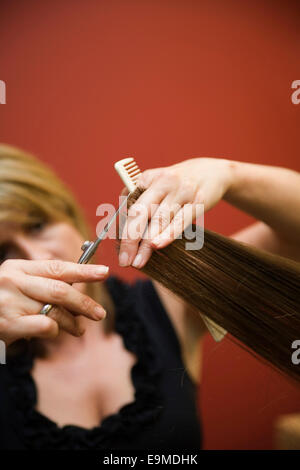 Ein Friseur, eine Frau die Haare schneiden Stockfoto
