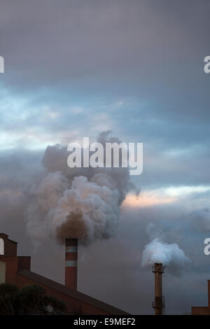 Rauch aus Schornsteinen gegen bewölktem Himmel Stockfoto
