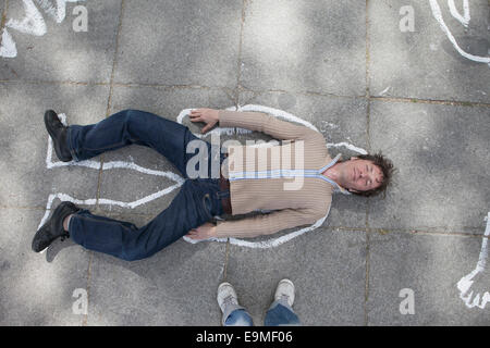 Erhöhte Ansicht der Kreide Umriss um Mann auf der Straße liegend Stockfoto