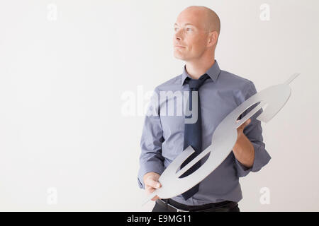 Zuversichtlich Geschäftsmann hält Dollarzeichen auf weißem Hintergrund Stockfoto