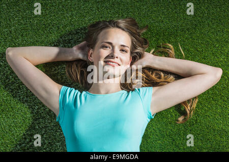 Hohen Winkel Porträt des lächelnden Frau liegt auf dem Rasen im park Stockfoto