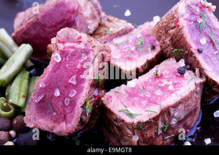 In Scheiben Rindfleischsteak auf einen Teller mit Bohnen Stockfoto