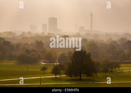 London, UK. 30. Oktober 2014.  Die Sonne beginnt zu durchbrechen, wie Nebel die Skyline von London hüllt, wie Wanderer Hund und Fitness-Fanatiker Primrose Hill genießen. Im Bild: Die Skyline von London überragt im Regents Park aufsteigenden Nebel. Bildnachweis: Paul Davey/Alamy Live-Nachrichten Stockfoto