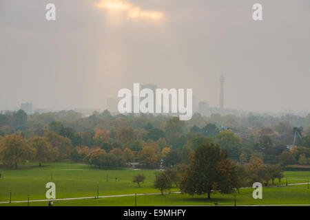 London, UK. 30. Oktober 2014.  Die Sonne beginnt zu durchbrechen, wie Nebel die Skyline von London hüllt, wie Wanderer Hund und Fitness-Fanatiker Primrose Hill genießen. Im Bild: Die Sonne durchbricht Baden London in weiches, diffuses Licht. Bildnachweis: Paul Davey/Alamy Live-Nachrichten Stockfoto