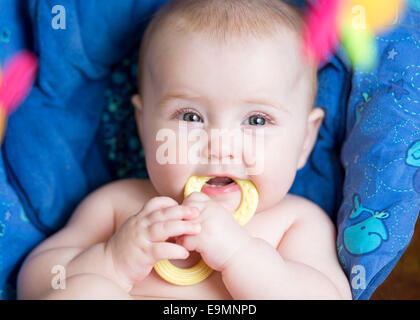 Babymädchen mit Beißring Verlegung Stockfoto