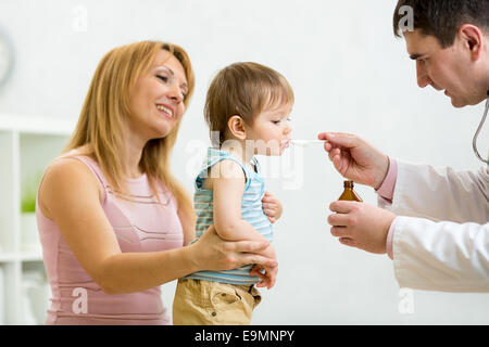 Arzt geben Löffel Dosis des Arzneimittels trinken Sirup für Kind Stockfoto