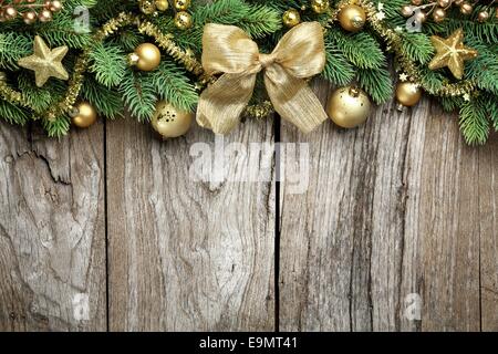 Tannenzweig und goldene Christbaumkugeln auf hölzernen Hintergrund Stockfoto