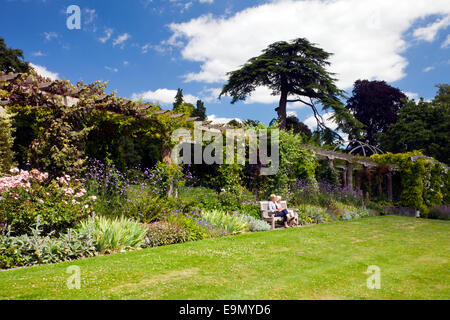 Genießen Sie die Sonne vor der 300 ft lange Edwardian Pergola in West Dean Gardens, West Sussex, England, UK Stockfoto