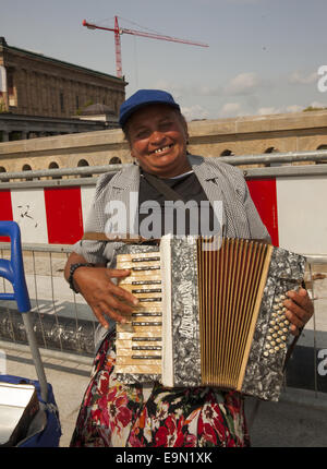 Älteren Straßenmusiker spielt das Akkordeon für Tipps auf der Brücke zur Museumsinsel in Berlin, Deutschland. Stockfoto