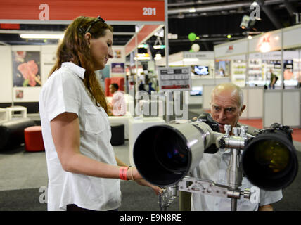 Johannesburg, Südafrika. 30. Oktober 2014. Aussteller (L) zeigt ein selbst entwickeltes Gerät, welche zwei Kameras ausgestattet sein können, Besucher während der Fotofilm & Expo in Johannesburg, Südafrika, am 30. Oktober 2014. Der Fotofilm & Expo, die die größte fotografische Expo in Afrika ist, startete hier am Donnerstag. Nach Angaben der Veranstalter die jährliche Veranstaltung bringt zusammen über 20.000 Industrie kreativen und über 400 fotografische Marken für 4 Tage in diesem Jahr und über 100 Präsentationen und Demonstrationen sollen angeboten werden. © Zhai Jianlan/Xinhua/Alamy Live-Nachrichten Stockfoto