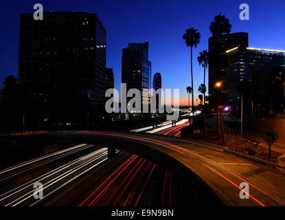 Autos verlassen leichte Wanderwege auf einem downtown Los Angeles Freeway in der Abenddämmerung. Stockfoto