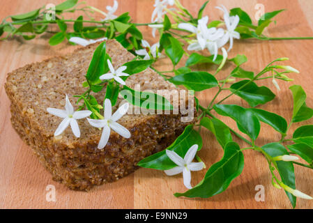 Roggen-Brot in Scheiben geschnitten auf Holztisch und Zitrone Blumen Stockfoto