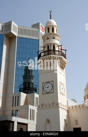 Das Minarett der ein Moscheen spiegelt sich in den Glaswänden des Amtes Batelco in Manama, Bahrain Stockfoto