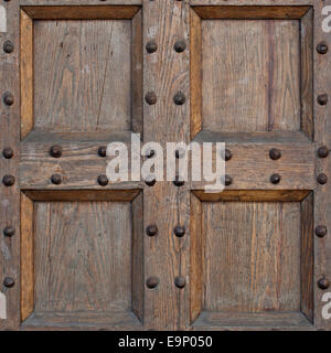 Detail der alten feste Tür. Holz und Metall Tür mit metallischen Spitzen sehen abgenutzt und schäbig. Teil der alten Burg oder Festung. Stockfoto