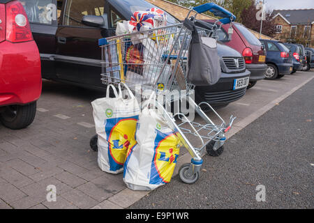 Einkaufswagen und Einkaufstaschen voller auf einem Parkplatz in einem Lidl-Supermarkt einkaufen Stockfoto