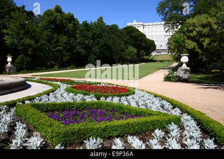 Blumen und Blumenbeete in Campo de Moro Gärten / Jardines del Palacio Real, Königspalast dahinter, Madrid, Spanien Stockfoto