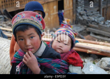 Ein fünf Jahre altes trägt seinen kleinen Bruder im Himalaya Stockfoto
