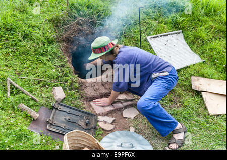 Mit einem Erdofen oder einer Kochgrube, die in den Hang eines Feldes gegraben wurde Stockfoto