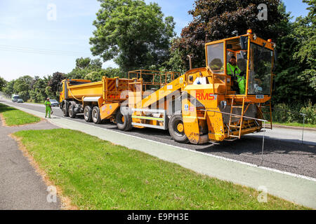 Ein Lastwagen oder ein LKW, der oder der Asphalt auf einer Hauptstraße Stoke-on-Trent, Staffordshire, England, Großbritannien anlegt Stockfoto