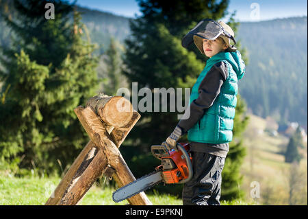 Junge von zehn mit Kettensäge Stockfoto