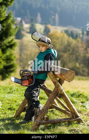 Junge von zehn mit Kettensäge Stockfoto