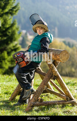 Junge von zehn mit Kettensäge Stockfoto