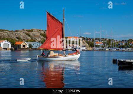 Segelboot mit roten Segeln Kreuzfahrten durch die Meerenge in Marstrand, Schweden Stockfoto