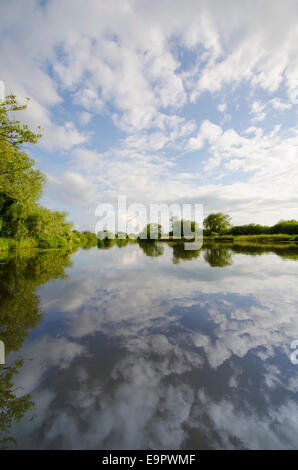 Wolkenformationen und Reflexionen über den Fluß Yare in der Nähe von Surlingham, Norfolk, Großbritannien. Juni. Blick nach Westen. Stockfoto