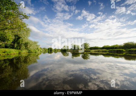 Wolkenformationen und Reflexionen über den Fluß Yare in der Nähe von Surlingham, Norfolk, Großbritannien. Juni. Blick nach Westen. Stockfoto