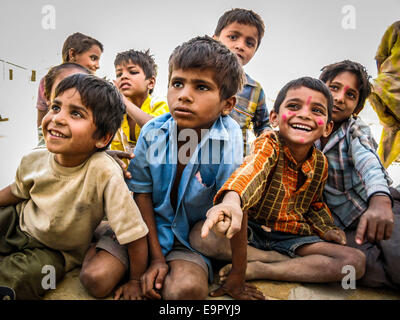 Glückliche indische Kinder draußen sitzen und lachen über Wüste Dorf in Jaisalmer, Rajasthan, Indien. Stockfoto