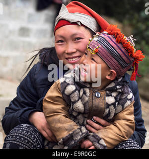 Glückliche Hmong Frau und Kind Lächeln, draußen zu sitzen, an Giang Ta Chai Dorf in der Nähe von Sapa Stadt, Provinz Lao Cai, Vietnam. Stockfoto