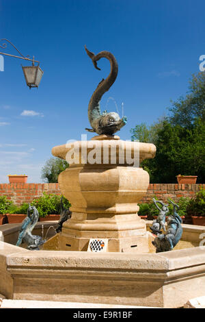 Siena, Toskana, Italien. Delphinbrunnen in über Fontanella Kennzeichnung Gebiet der Onda Contrada. Stockfoto