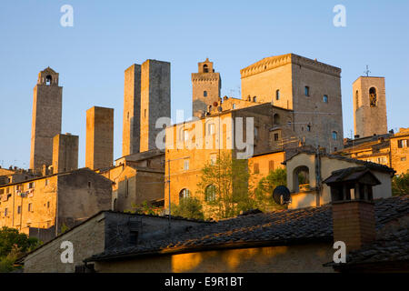 San Gimignano, Toskana, Italien.  Cluster der mittelalterlichen Türme durch die aufgehende Sonne beleuchtet. Stockfoto