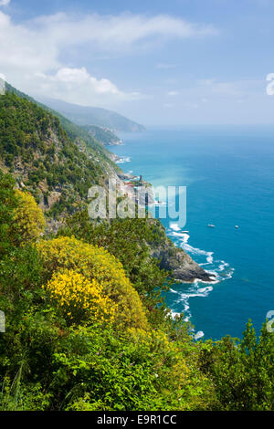 Vernazza, Nationalpark Cinque Terre, Ligurien, Italien. Blick auf den entfernten Dorf von Fußweg über zerklüftete Küste. Stockfoto